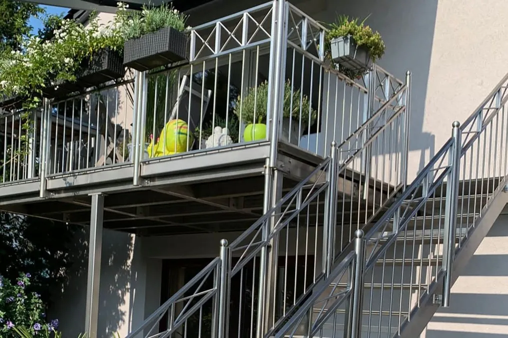 Balkon mit Außentreppe und Edelstahlgeländer, bepflanzt