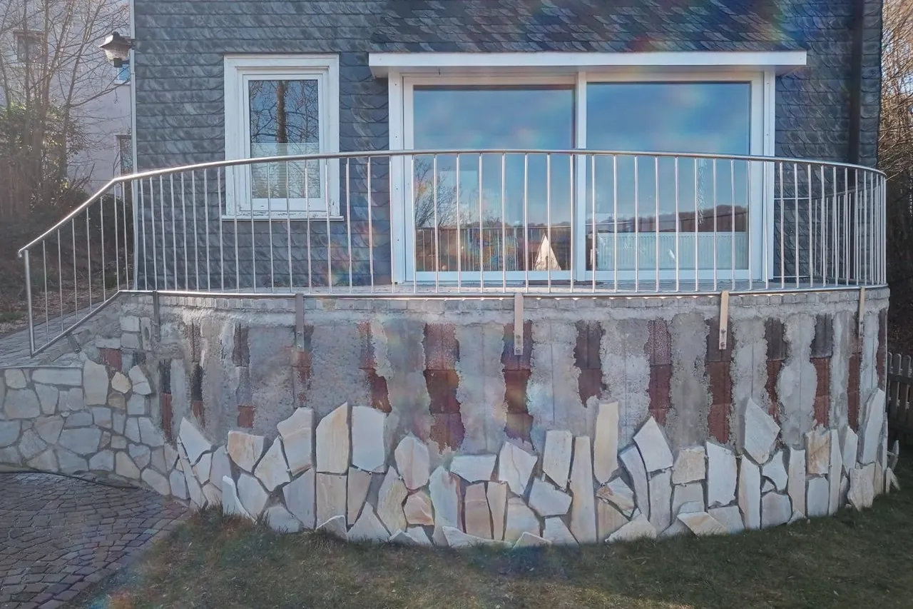 Edelstahlgeländer auf einer Natursteinmauer